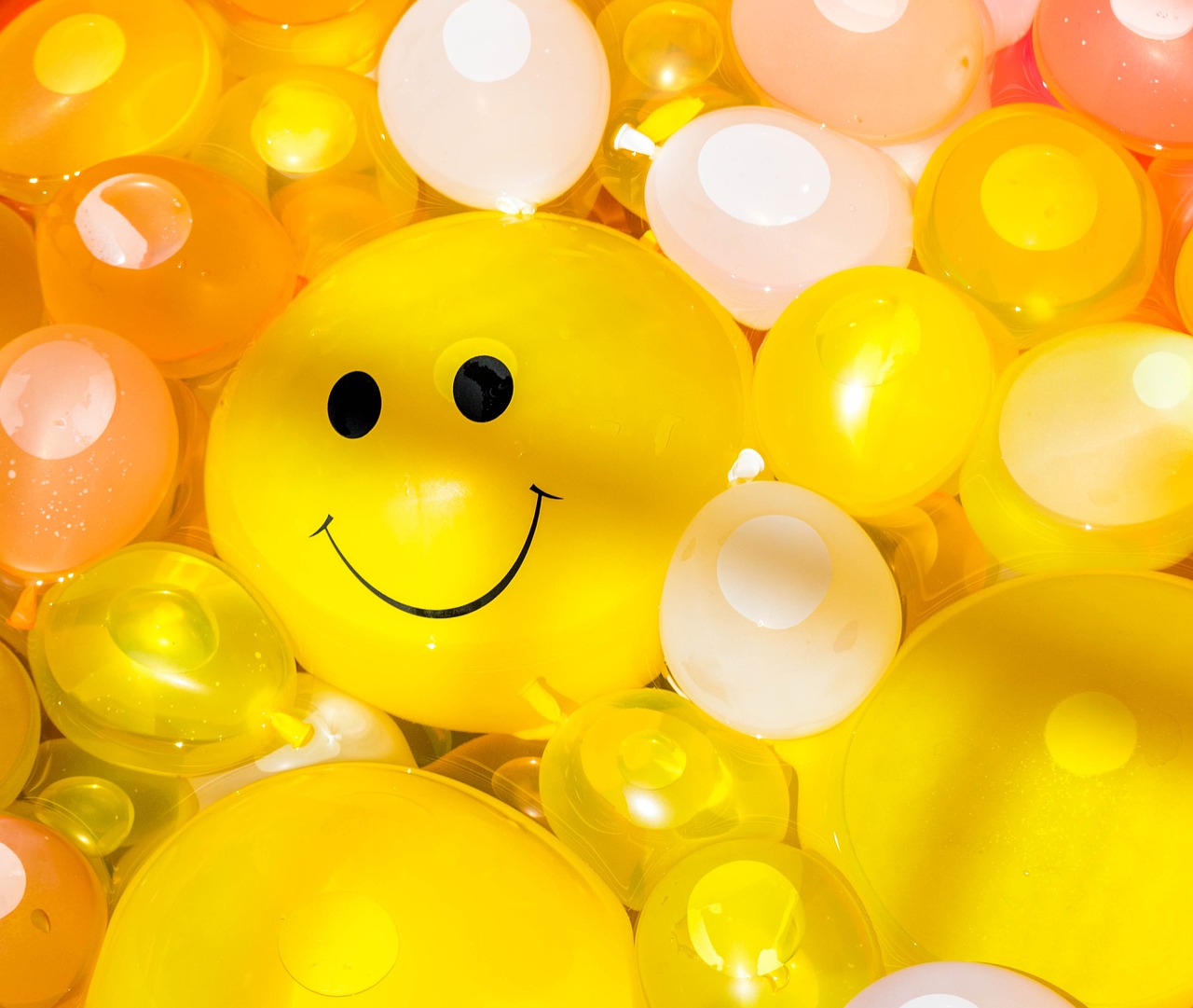 a large bunch of balloons with a smiling face