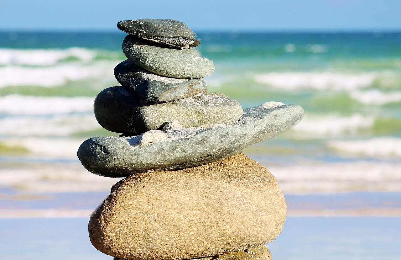 some very nice rocks stacked up in front of the ocean