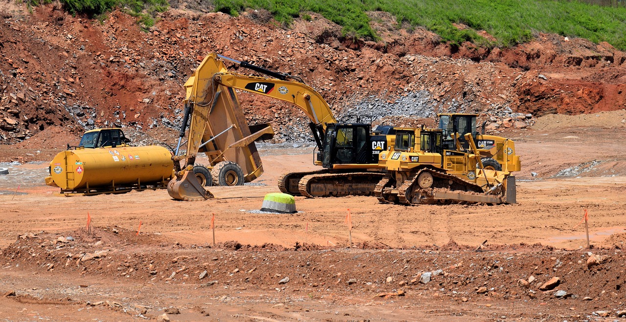 two construction equipment in the desert dirt