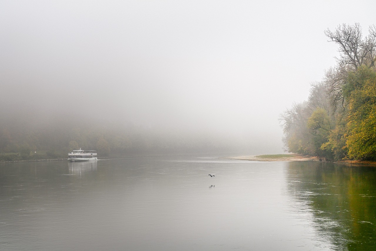 a boat is on the river in the mist
