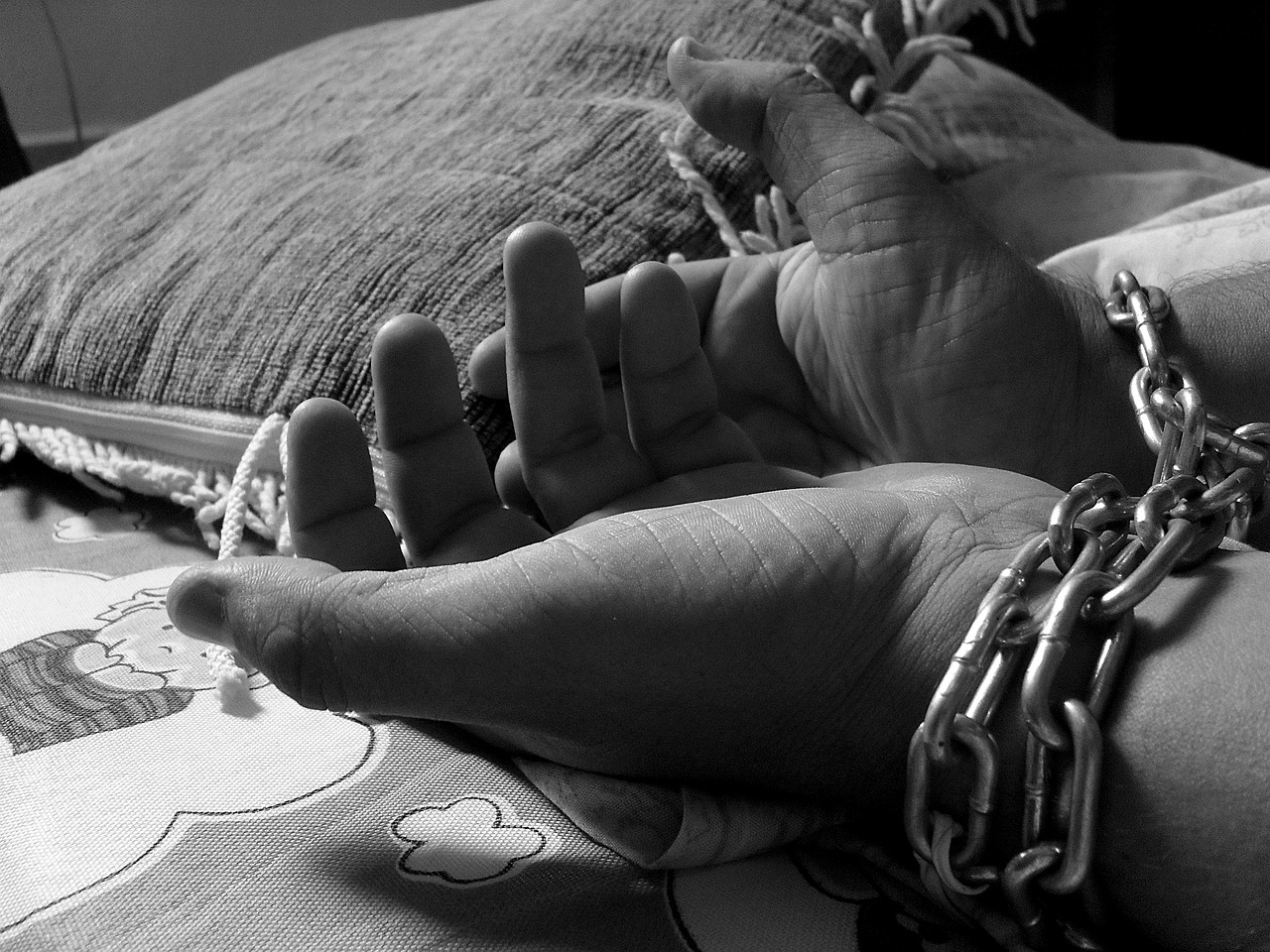 a hand on a chain on top of a bed