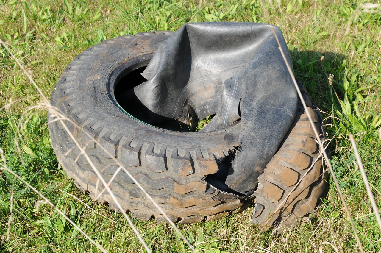 a worn up tire on the ground in a field