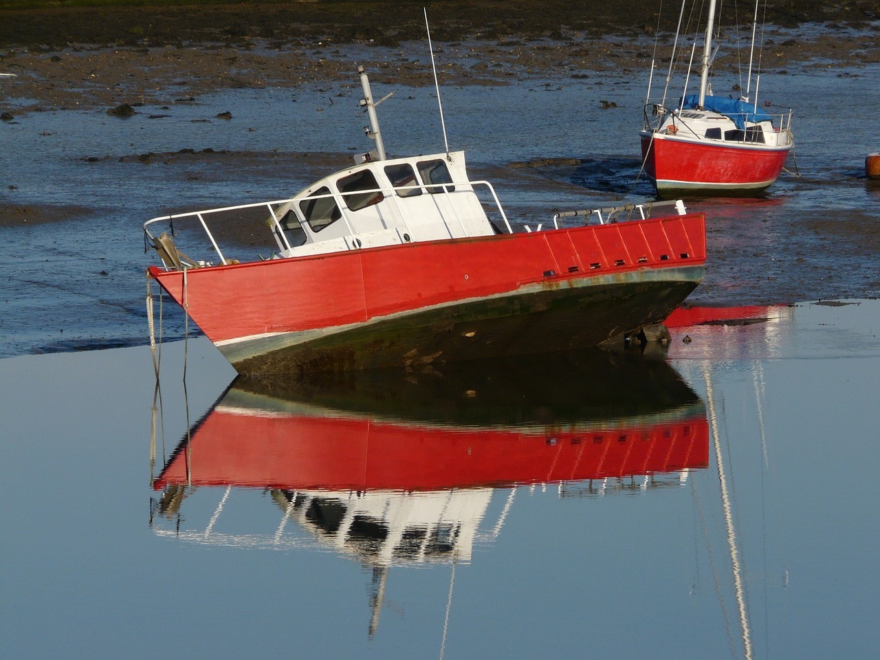 two red and white boats floating in water next to each other