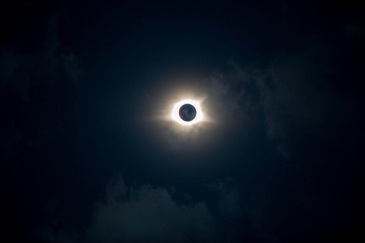 the moon corona with its very bright disk, surrounded by dark clouds