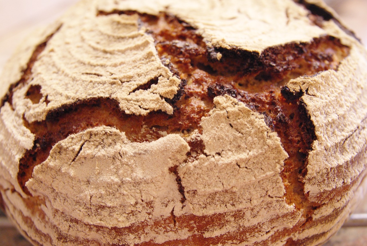 close up of a sour crumb covered baked item on metal rack