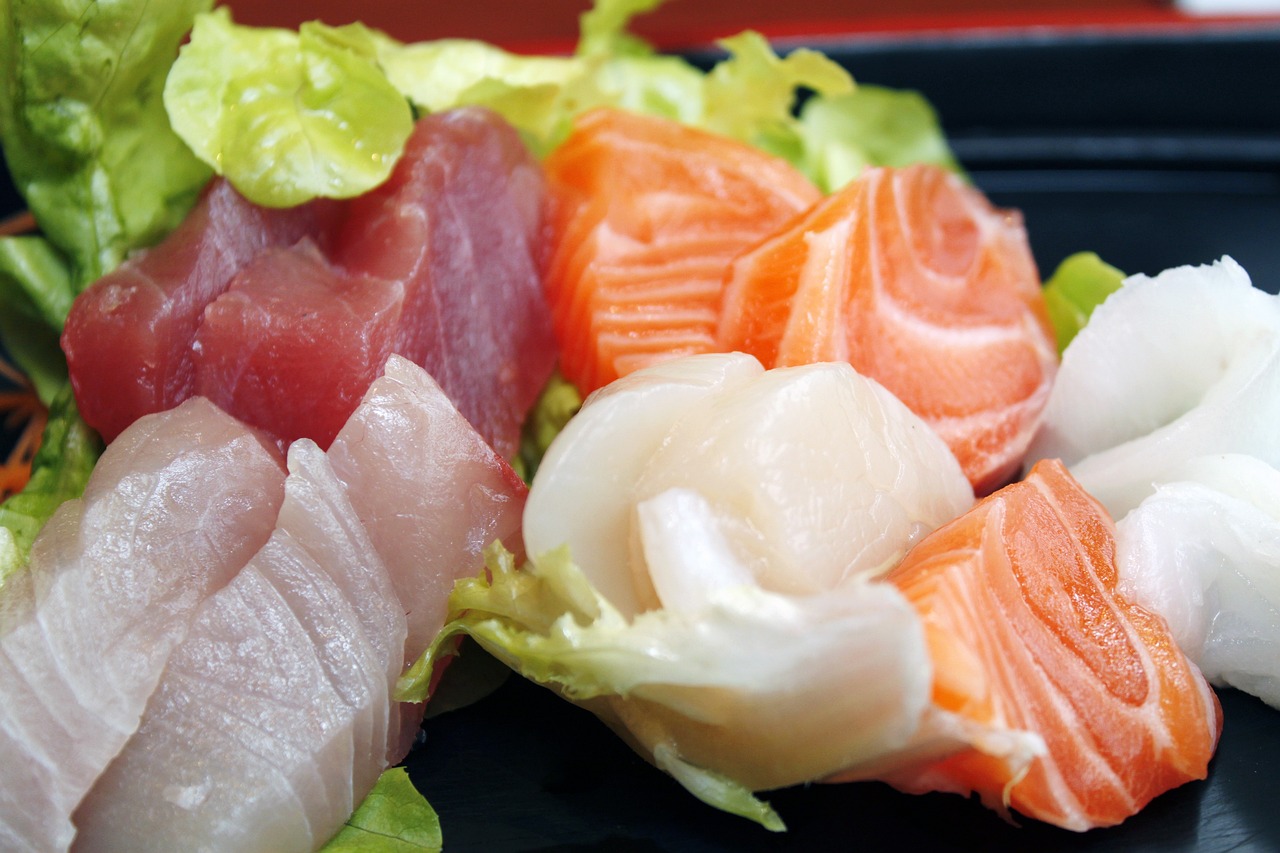 some fish and lettuce on a black plate