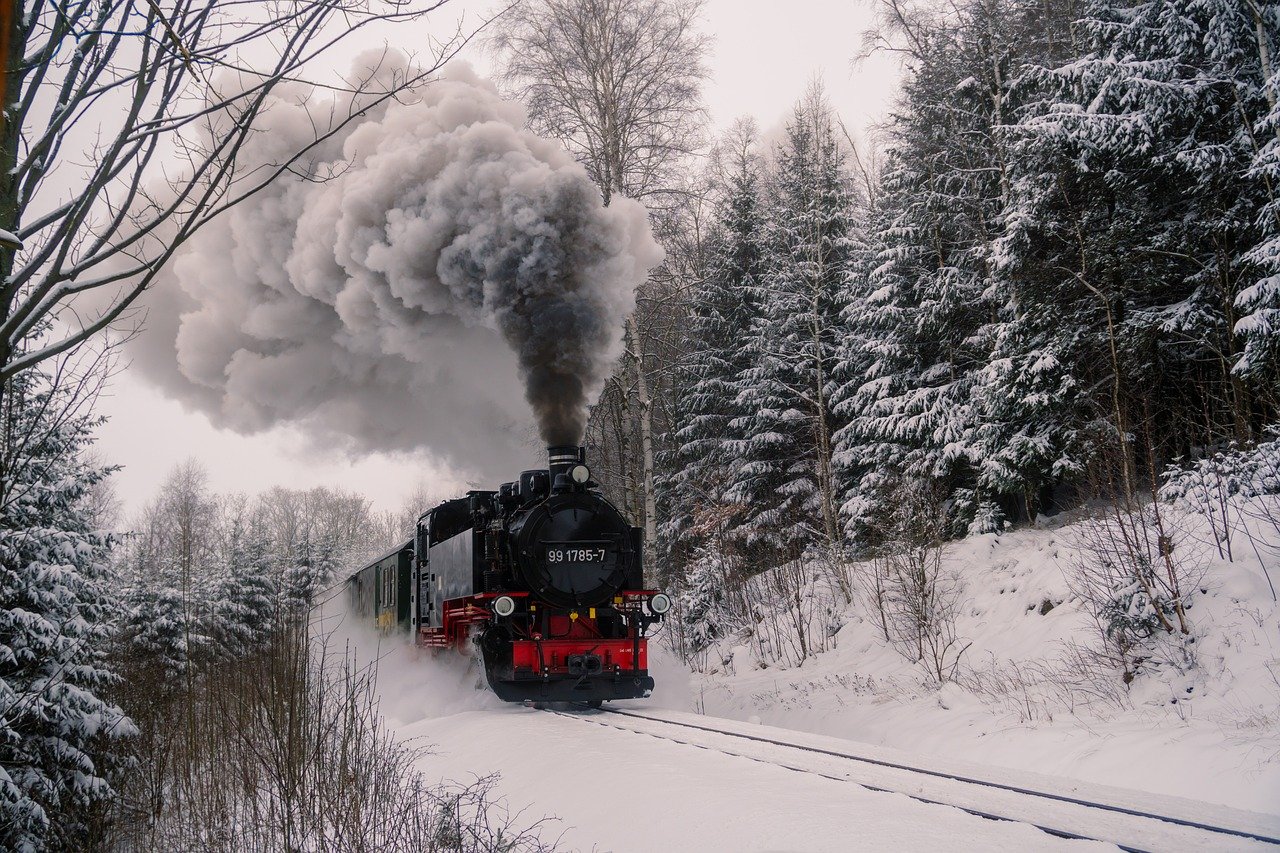 a train traveling down a snowy road with a steam engine