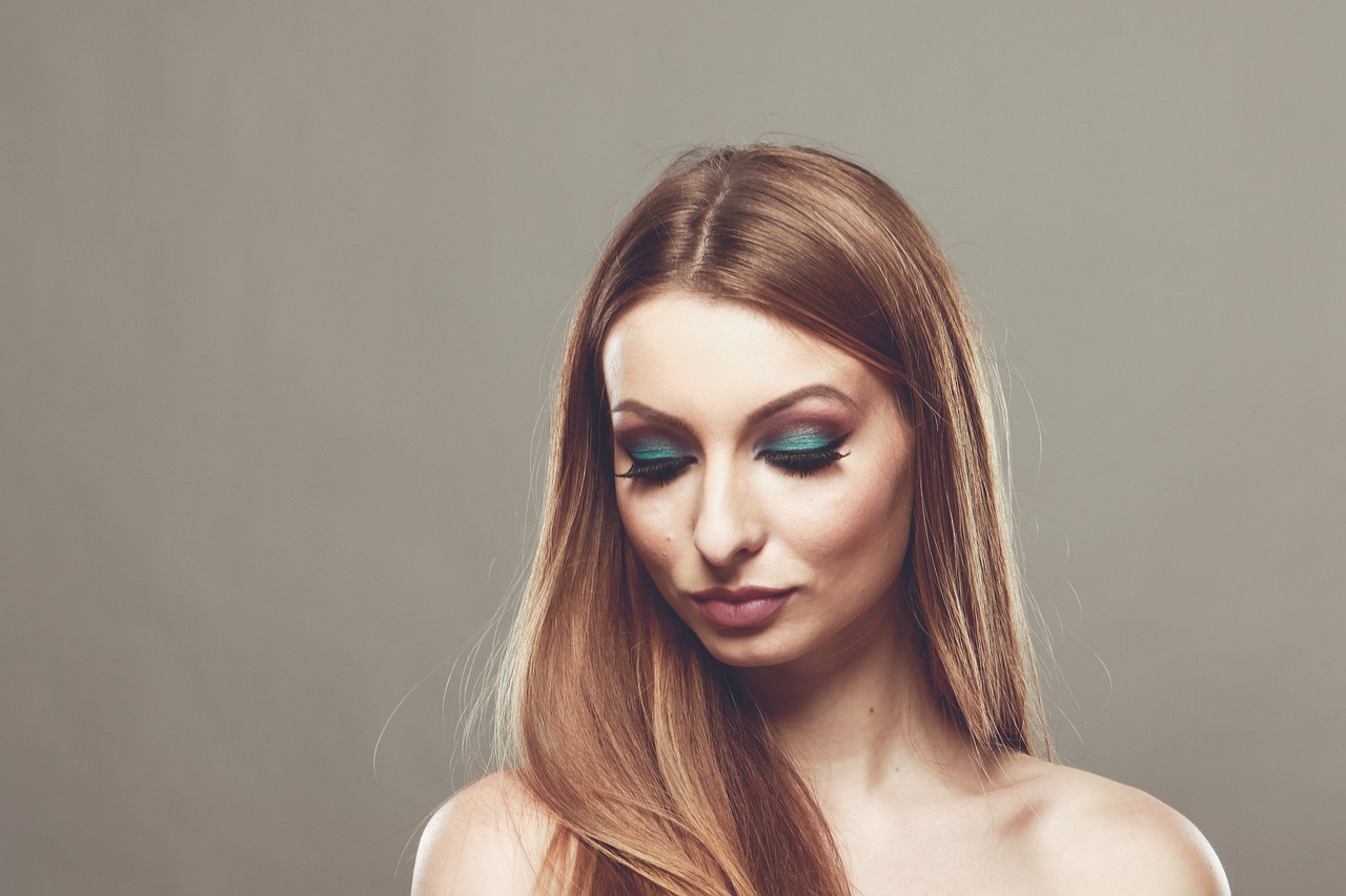 a beautiful woman with long hair wearing green eyeshade