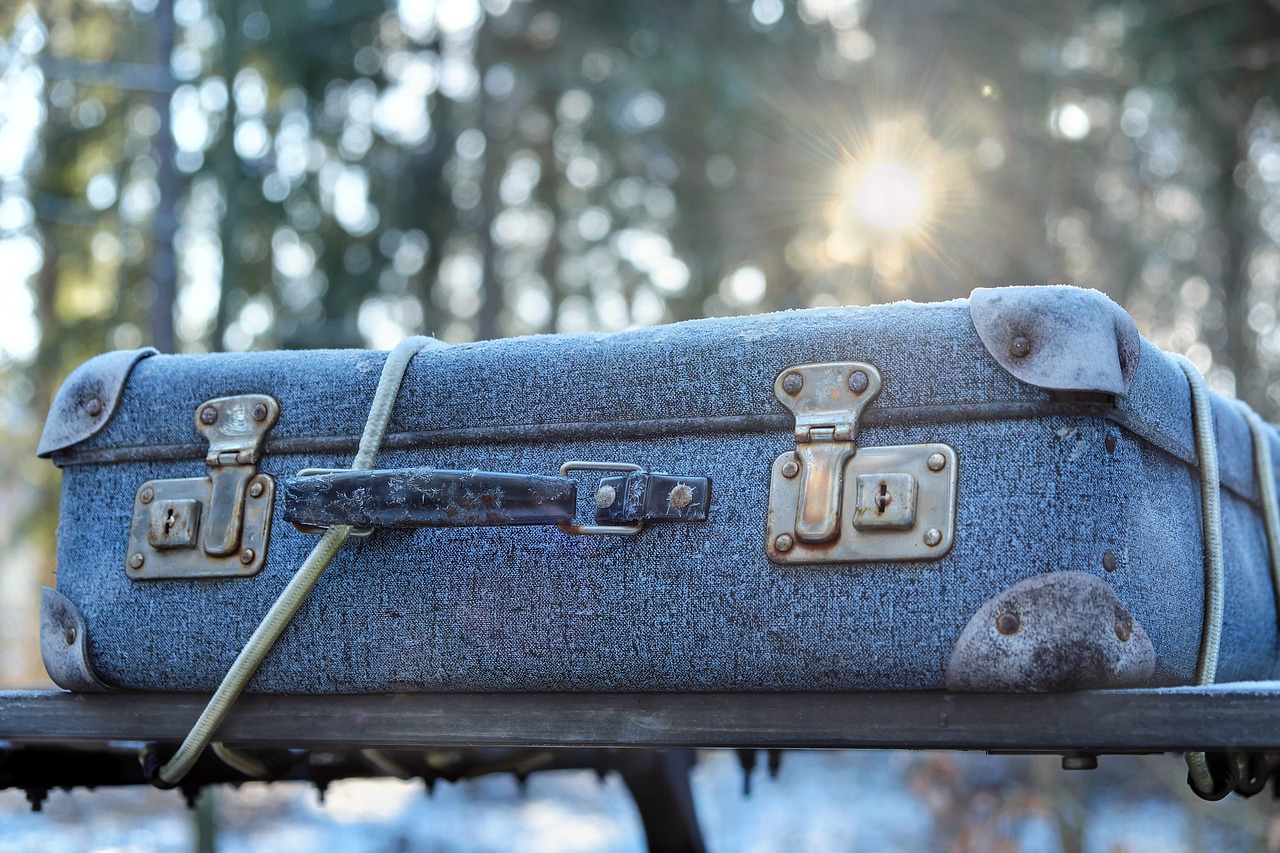 an old denim suitcase sitting on top of a bench