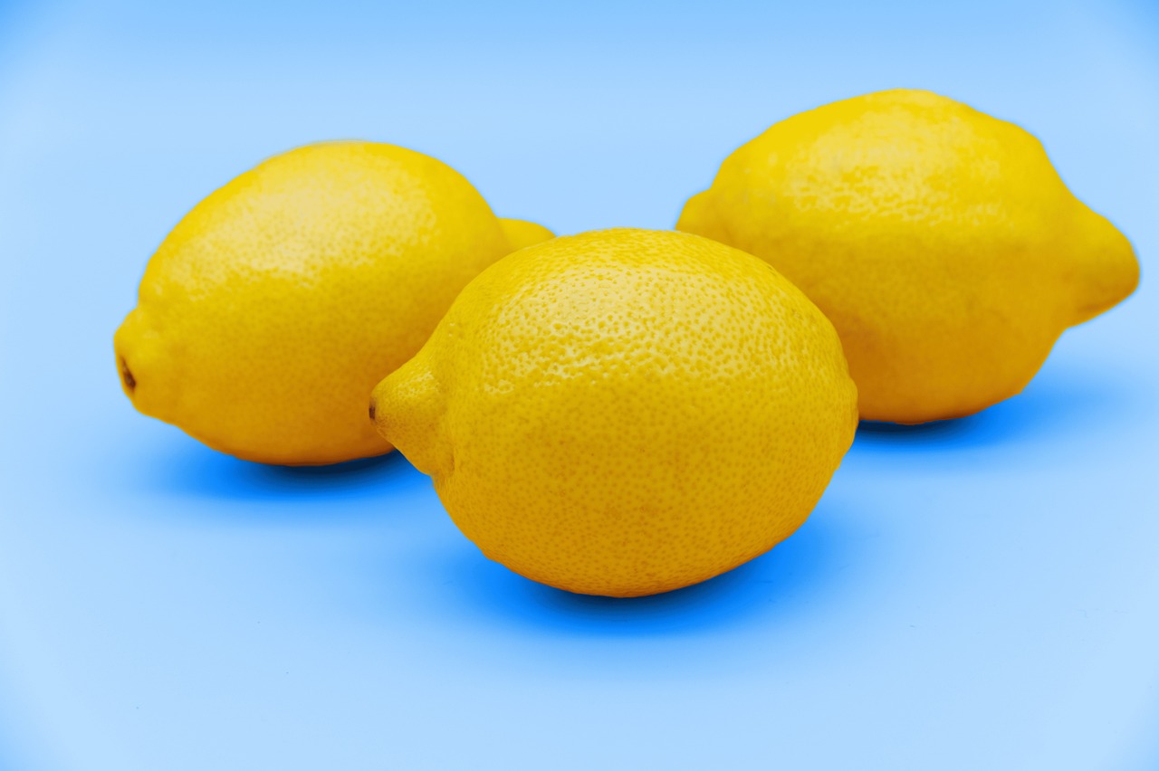 three lemons are pictured on a blue background