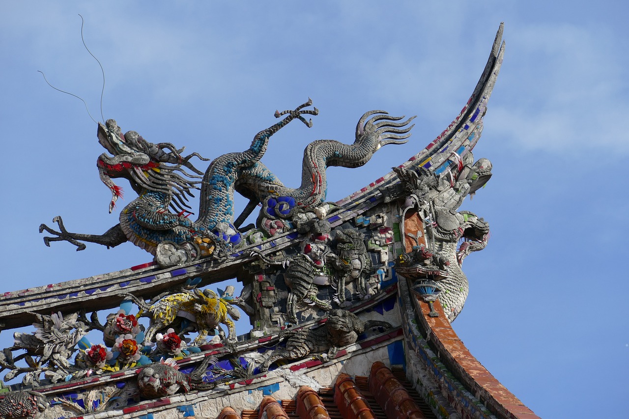 a colorful sculpture with two winged creatures on it's roof