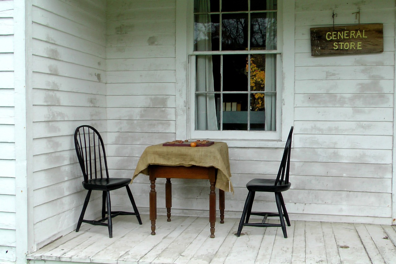 two chairs sitting on a porch next to a table