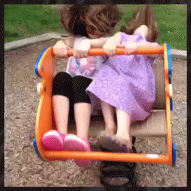 two little girls sitting in the blue toy car