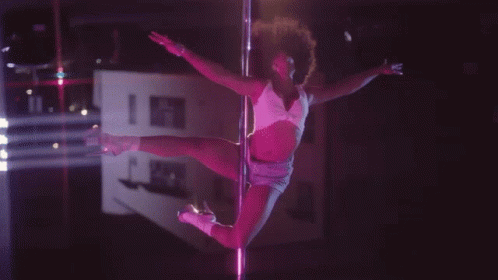 a woman with an afro dancing on the pole