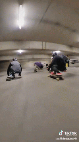 four snowboarders riding down a long tunnel