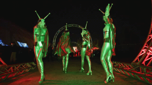 an alien dance show at night in front of a crowd
