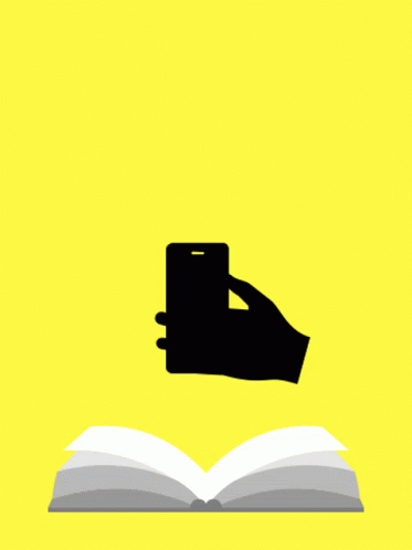a hand holding a phone next to an open book
