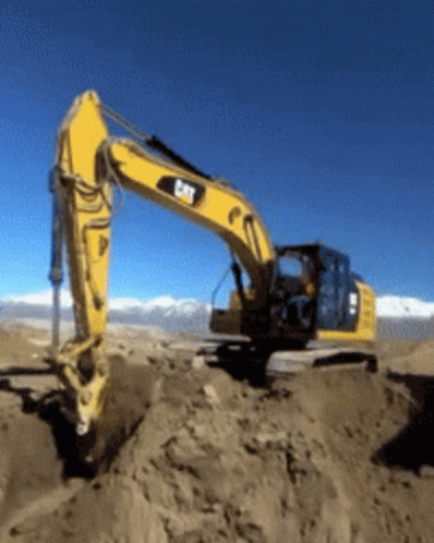 an excavator truck sitting on top of a mountain