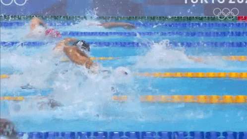 several men swimming in a pool next to each other