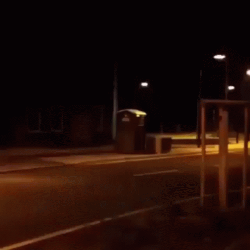 night time street scene with parking meters in the dark