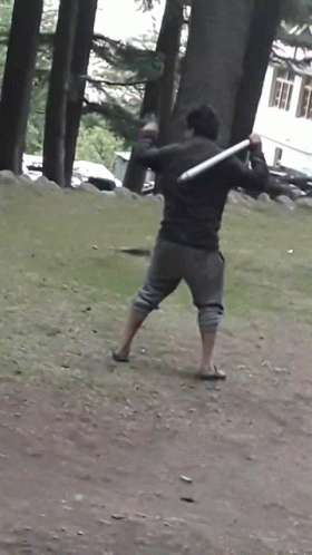 a man in green pants holding a baseball bat