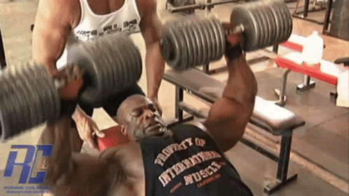 people lifting a large barbell in a gym