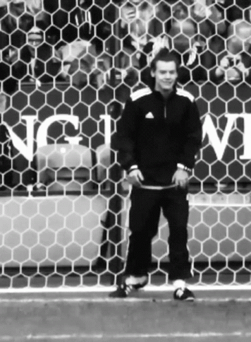 a soccer player standing behind a goal