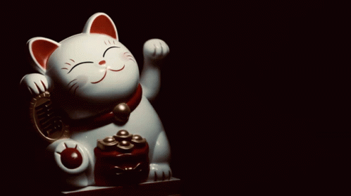 a ceramic figurine of a cat has its eyes closed