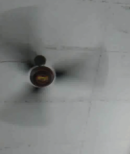 a fan sitting on top of a white wall