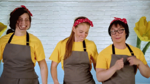 a group of women are smiling while wearing aprons