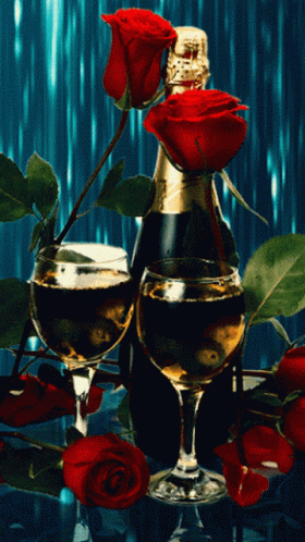 two roses sit near an empty glass and a bottle