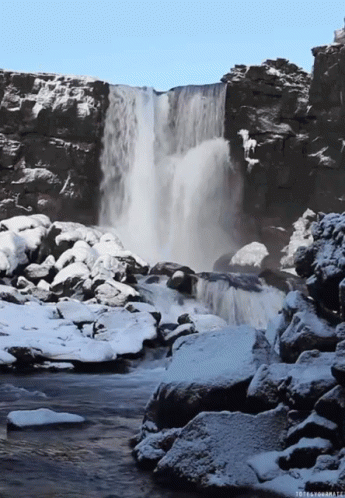 waterfall with rocks and snow covered ground