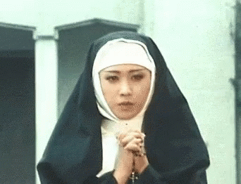 woman wearing a nun outfit while holding a cross