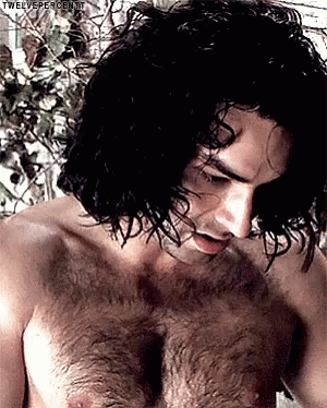 a hairy young man poses with his hands on his chest