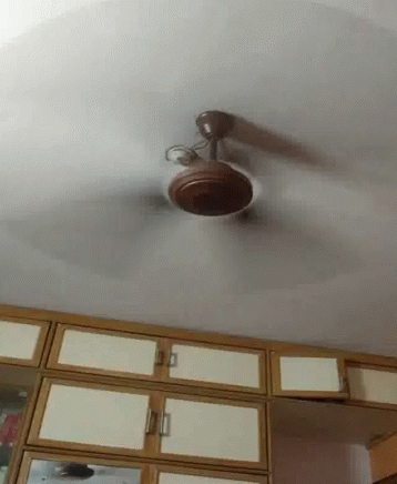 the ceiling fan on the ceiling has a light shining in it