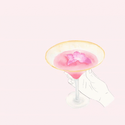 a hand is holding a purple beverage in a glass