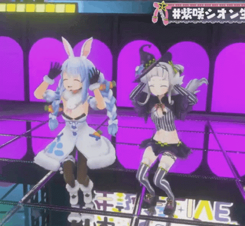 two females in anime clothes posing on a stage
