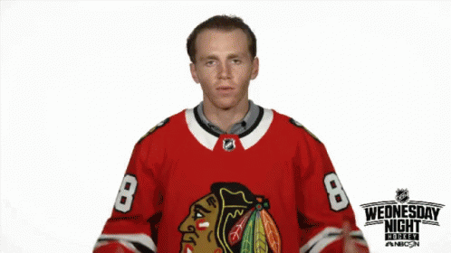 a man in a hockey uniform standing in front of a white background