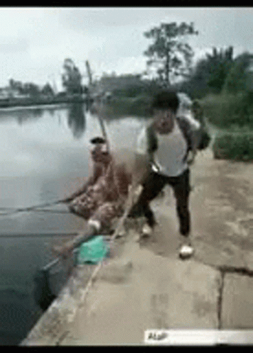 two men on the side of a lake playing with a string