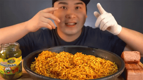 a man wearing gloves over a bowl full of rice
