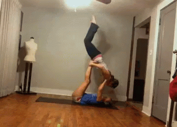 the man is doing an upside down exercise in the room