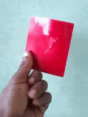 a person holding up a purple card in their left hand