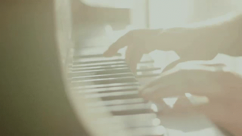 a person at a piano playing music in blurry picture
