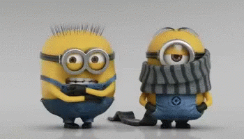 two blue toy minion standing side by side, both with eyes