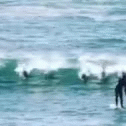 an blurry image of two surfers in the ocean