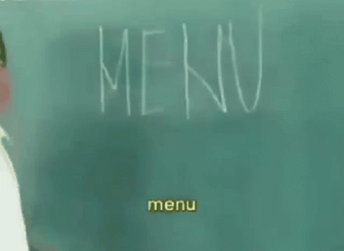 a man wearing white is standing in front of a chalkboard with a menu