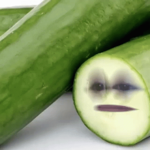 the cucumber has a sad face and is next to a green object
