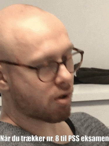 a man with glasses and a bald head is wearing glasses