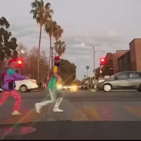 two people are crossing the street at night