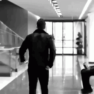 a man walking down the hallway talking on his cellphone